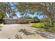 Pink single story home with circular driveway, mature trees, and lush landscaping at 1131 Snell Isle Ne Blvd, St Petersburg, FL 33704