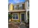 Two-story yellow townhome with gray door and landscaping at 1252 Costa Mesa Dr, Wesley Chapel, FL 33543