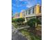Row of townhomes with yellow and beige exteriors and landscaping at 1252 Costa Mesa Dr, Wesley Chapel, FL 33543