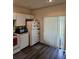 Galley kitchen with appliances, dark laminate floor, and access to backyard at 1252 Costa Mesa Dr, Wesley Chapel, FL 33543
