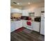 Kitchen with white cabinets, appliances, and dark floors at 1252 Costa Mesa Dr, Wesley Chapel, FL 33543