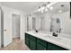 Modern bathroom with dual vanity and green cabinets at 12612 Midpointe Dr, Riverview, FL 33579