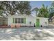 Charming single story home with a green door and landscaped yard at 1428 Illinois Ave, Palm Harbor, FL 34683