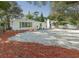 White single story house with gravel driveway and red mulch landscaping at 1428 Illinois Ave, Palm Harbor, FL 34683