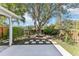 Landscaped backyard with stepping stones and large tree at 15624 Morning Dr, Lutz, FL 33559