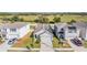 Aerial view of three houses with solar panels, showcasing curb appeal and neighborhood setting at 16838 Delia St, Wimauma, FL 33598
