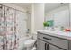 Clean bathroom with shower/tub combo, gray vanity, and white toilet at 16838 Delia St, Wimauma, FL 33598