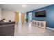 Living area with grey couch, media console, and access to patio at 16838 Delia St, Wimauma, FL 33598