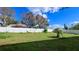 Large backyard with grassy area and white vinyl fence at 2012 Fern Ridge Ct, Holiday, FL 34691