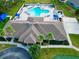 Community pool with surrounding lounge chairs and volleyball court at 2012 Fern Ridge Ct, Holiday, FL 34691