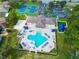 Community pool with surrounding lounge chairs and tennis courts at 2012 Fern Ridge Ct, Holiday, FL 34691