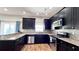 Modern kitchen with dark cabinetry, granite countertops, and stainless steel appliances at 2012 Fern Ridge Ct, Holiday, FL 34691