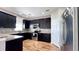 Modern kitchen with dark cabinetry, granite countertops, and stainless steel appliances at 2012 Fern Ridge Ct, Holiday, FL 34691