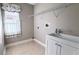 Bright laundry room with built-in shelving and sink at 2012 Fern Ridge Ct, Holiday, FL 34691