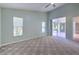 Spacious bedroom with carpet flooring, ceiling fan, and sliding glass doors to the patio at 3125 Bent Creek Dr, Valrico, FL 33596