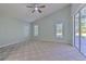 Primary bedroom with carpet flooring, ceiling fan, and sliding glass doors to the patio at 3125 Bent Creek Dr, Valrico, FL 33596