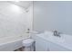 This bathroom offers a shower-tub with marble tiling, a new toilet, and a sink with storage at 3562 Fisher Rd, Palm Harbor, FL 34683