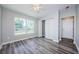 This bedroom features light gray walls, a gray wood floor, and double doors to a closet at 3562 Fisher Rd, Palm Harbor, FL 34683