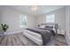 A staged bedroom with a gray platform bed, neutral walls, and sleek, modern nightstand at 3562 Fisher Rd, Palm Harbor, FL 34683