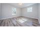 This bedroom features light gray walls, a gray wood floor, and windows with views at 3562 Fisher Rd, Palm Harbor, FL 34683