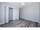 This bedroom features light gray walls, a gray wood floor, and double doors to a closet at 3562 Fisher Rd, Palm Harbor, FL 34683