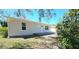 A charming home exterior showcasing a well-maintained lawn, new windows, and a quaint front porch entrance at 3562 Fisher Rd, Palm Harbor, FL 34683