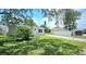 Charming single-story home featuring a well-maintained lawn and a driveway leading to a detached garage at 3562 Fisher Rd, Palm Harbor, FL 34683