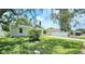 Charming single-story home featuring a well-maintained lawn and a driveway leading to a detached garage at 3562 Fisher Rd, Palm Harbor, FL 34683