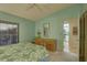 Bright bedroom with a dresser and a large window, adorned with a green floral bedspread at 4452 Weybridge St # 74, Sarasota, FL 34235