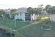 Exterior view of the condo complex with well manicured lawns, lush landscaping, and scenic pond views at 4452 Weybridge St # 74, Sarasota, FL 34235