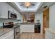 Open kitchen view featuring stainless appliances and granite counters overlooking the living area at 4452 Weybridge St # 74, Sarasota, FL 34235
