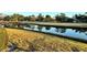 Scenic community pond reflecting the surrounding green golf course and blue skies at 4452 Weybridge St # 74, Sarasota, FL 34235