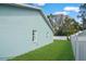 Side yard with a well-maintained lawn and white fence at 5112 Teather St, Spring Hill, FL 34608