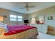 Bright bedroom featuring a red comforter and ceiling fan at 7050 Sunset S Dr # 405, South Pasadena, FL 33707