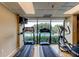 Well-equipped gym with treadmills and elliptical machines overlooking a pool at 7050 Sunset S Dr # 405, South Pasadena, FL 33707