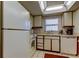 Bright kitchen with white appliances and wood cabinets at 7050 Sunset S Dr # 405, South Pasadena, FL 33707