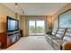 Living area with large TV, comfy seating, and sliding doors to balcony at 7050 Sunset S Dr # 405, South Pasadena, FL 33707