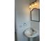 Bright bathroom featuring a pedestal sink, a large mirror, and decorative lighting at 10170 64Th Ave, Seminole, FL 33772