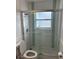 Bathroom featuring a glass-enclosed shower with tile and a matching toilet at 10170 64Th Ave, Seminole, FL 33772