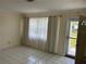 Bright living room with tile floors, sheer curtains and a glass front door at 10170 64Th Ave, Seminole, FL 33772