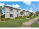 Low-rise condo building with mature landscaping, sidewalks, and reserved resident parking at 122 E Cypress Ct # 22, Oldsmar, FL 34677
