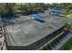 An aerial view showcases well-maintained tennis courts with shaded seating areas, highlighting an active lifestyle amenity at 122 E Cypress Ct # 22, Oldsmar, FL 34677