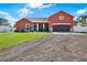 Front view of a two story house with a gravel driveway at 12494 Moon Rd, Brooksville, FL 34613