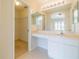 Main bathroom with vanity, double sinks, and a walk-in closet at 1257 Corinth Greens Dr # 1257, Sun City Center, FL 33573