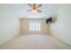 Main bedroom with carpeted floor, ceiling fan, and large window at 1257 Corinth Greens Dr # 1257, Sun City Center, FL 33573