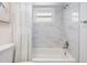 Bathroom with white marble tile and a tub shower combo at 2240 Colonial Dr, Dunedin, FL 34698