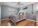 Bedroom with wood floors, ceiling fan and gray bedding at 2240 Colonial Dr, Dunedin, FL 34698