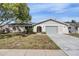 Single-story home with attached garage and well-maintained lawn at 2240 Colonial Dr, Dunedin, FL 34698