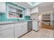 Kitchen with teal tile backsplash, stainless steel appliances, and white cabinets at 2240 Colonial Dr, Dunedin, FL 34698