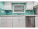 Kitchen boasts teal tile backsplash and stainless steel dishwasher at 2240 Colonial Dr, Dunedin, FL 34698